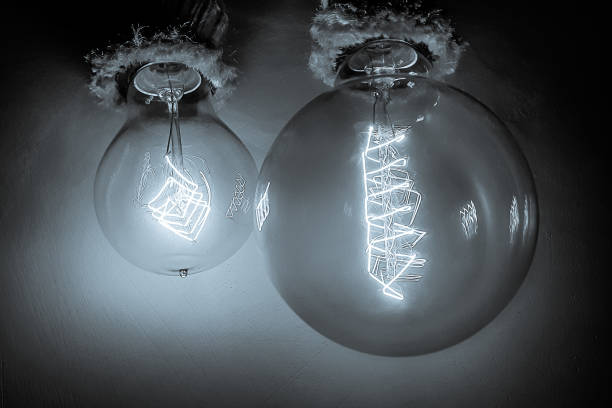istock Edison light bulbs with a tungsten spiral in a vacuum close-up next to a concrete wall 2149074577