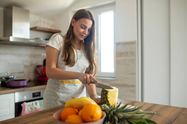 istock Young  beautiful woman preparing fruit salad for herself 2149074965