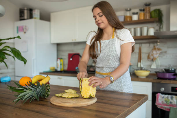 istock Young  beautiful woman preparing fruit salad for herself 2149074966