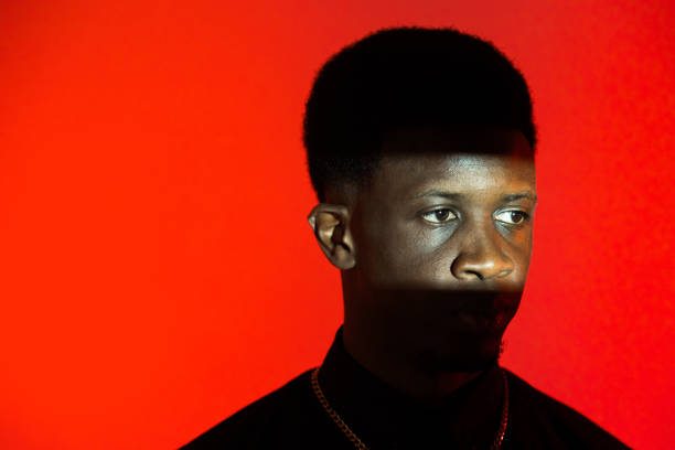 istock Black man wearing necklace against red background 2149076420