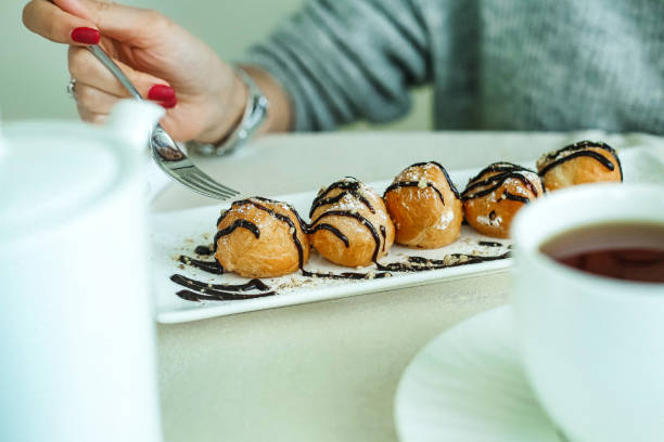 istock Woman Holding Fork Over Plate of Pastries 2149076796