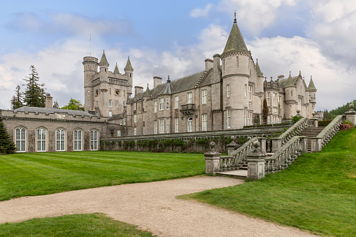 Crathie - United Kingdom. May 26, 2023: The elegant Balmoral Castle, with its ornate stonework and iconic towers, is captured here against the serene Scottish landscape