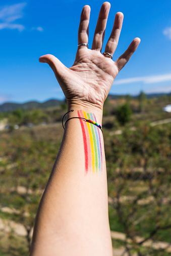 Unrecognizable person with bracelet and colors of the LGTBI+ flag
LGTBI protest conceptual