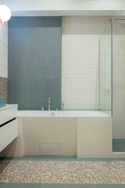 middle age woman measuring the water temmperature in the bathroom