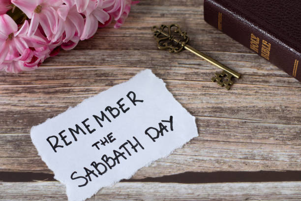 istock Remember the Sabbath Day, handwritten note with holy bible, ancient key, and spring flower on wooden table 2149079286