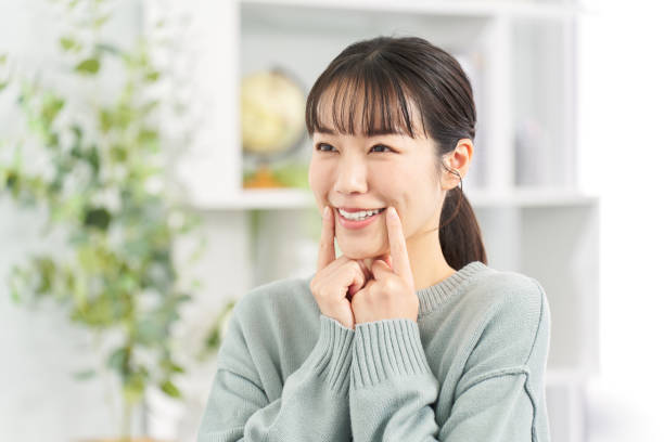 istock A woman practicing smiling in the living room 2149079455