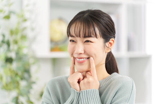 istock A woman practicing smiling in the living room 2149079460