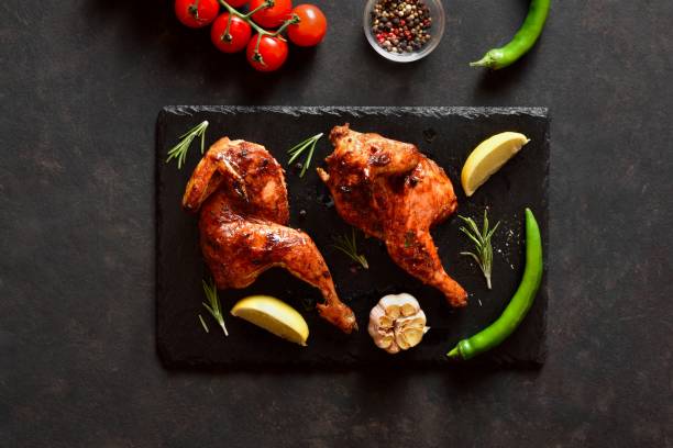 istock Grilled half chicken on black slate plate. Top view, flat lay 2149079948