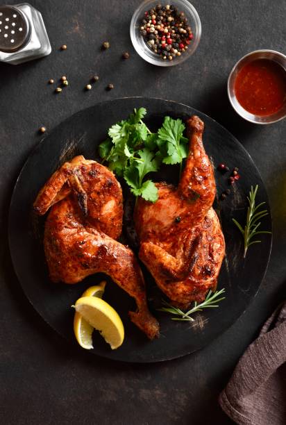 istock Roasted half chicken on black wooden board. Top view, flat lay 2149079949