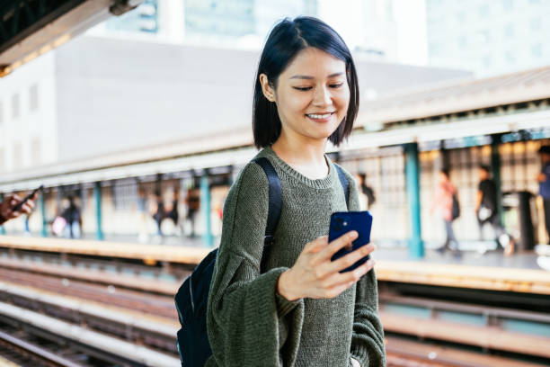istock Young Asian commuter on subway station, waiting for the metro train and using mobile phone 2149079990