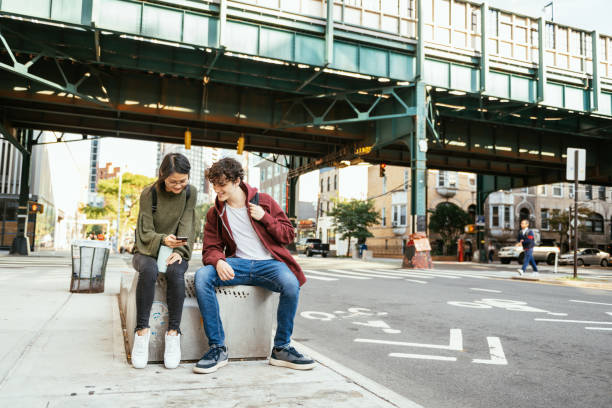 istock Young millennial couple in the city, using smart phone and mobile apps 2149080026