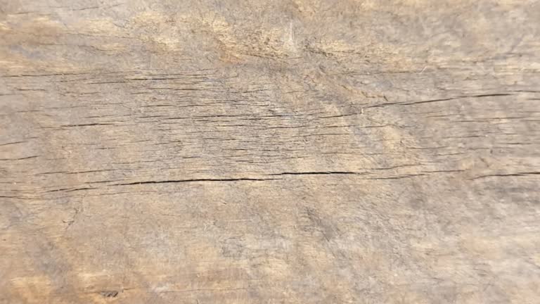 Zoom-in footage of a rusty old wooden surface with cracks. Wooden surface background