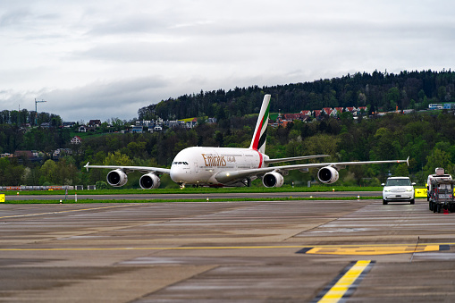 Emirates Airbus A380-861 airplane registration A6-EEI taxiing to terminal Dock Midfield at Swiss airport Zürich Kloten on a spring evening. Photo taken April 9th, 2024, Kloten, Switzerland.
