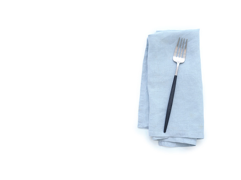 Top view blue linen kitchen napkin and cutlery isolated on white background. Folded cloth for mockup