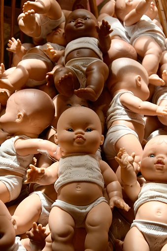 Pile of baby dolls displayed for sale, creepy toys
