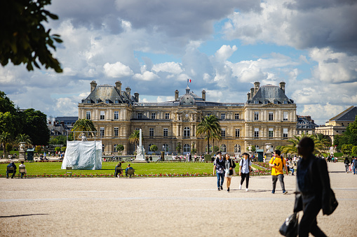 Paris, France - July 6, 2022: Tourists and local people in the Luxembourg Gardens with Luxembourg Museum (Musée du Luxembourg)