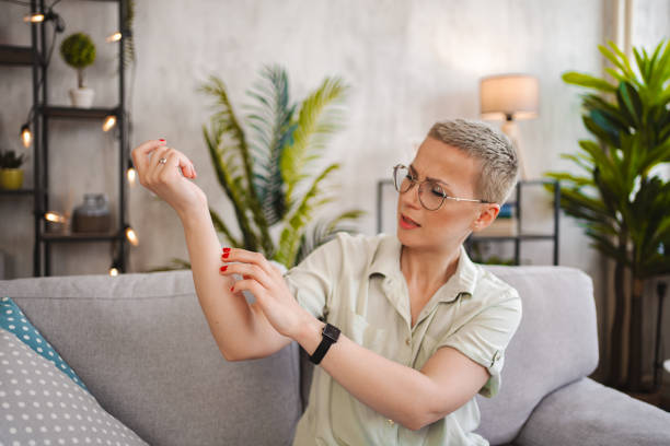 istock Woman scratching her itchy forearm while at home 2149083156