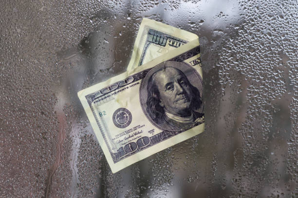 istock a dollar bill. stuck on the wet glass. the concept. 2149083939