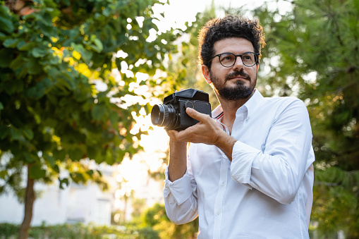 Portrait of young male photographer with camera in hand