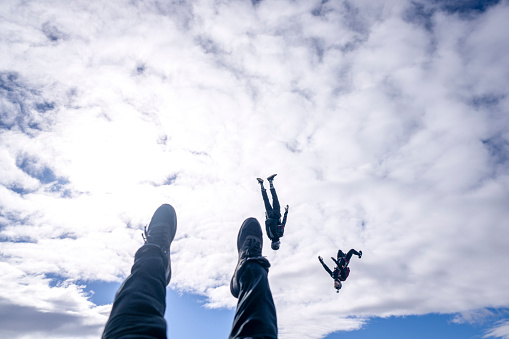 Freefall jumpers face each other mid-air and upside down in lofty clouds