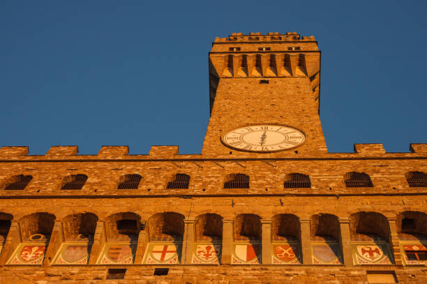 Tower of the Palazzo Vecchio is illuminated by the sunset. Bottom view