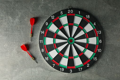 Darts hitting the target with wires on a gray background.