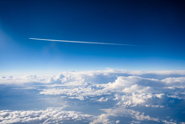 Commercial airplane flying over the clouds on a sunny day