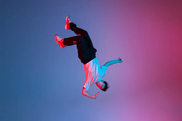 istock young guy falls upside down in the air, man levitates and flies down in neon lighting, acrobat dancer flies in a jump 2149085422