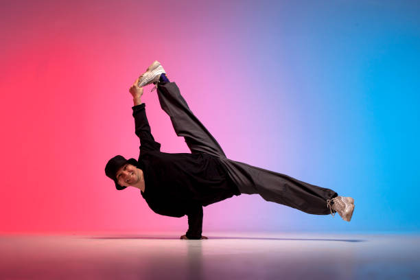 istock dancer doing acrobatic trick and dancing breakdance in neon red and blue lighting, young energetic guy 2149085453