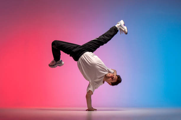 istock dancer doing acrobatic trick and dancing breakdance in neon red and blue lighting, young energetic guy 2149085471