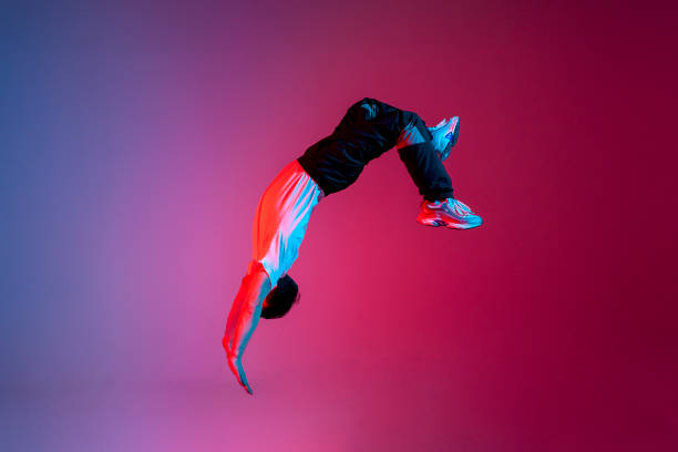 istock young guy falls upside down in the air, man levitates and flies down in neon lighting, acrobat dancer flies in jump 2149085481