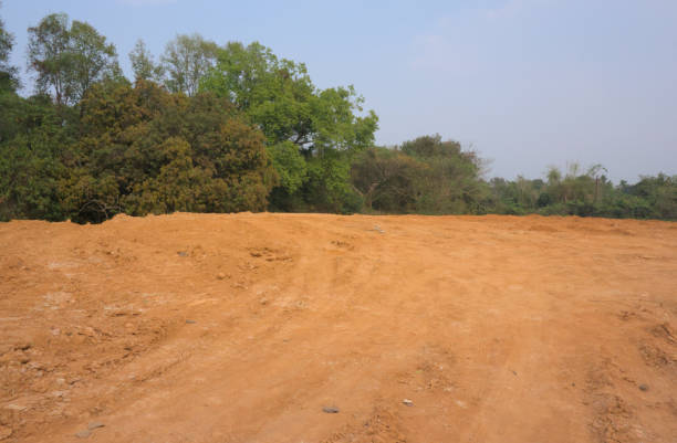 istock Red mud land with greenery and blue sky in the background 2149086030