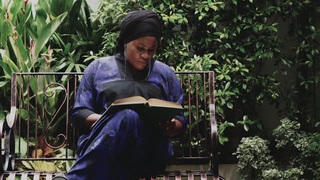 African woman reading a book alone