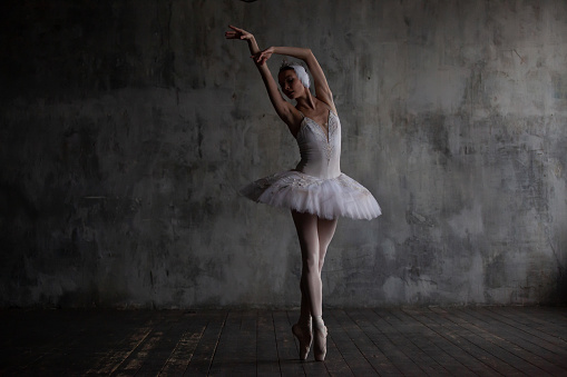Ballerina in a white ballet costume dances.