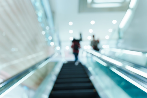 An escalator in a modern building with blurred people