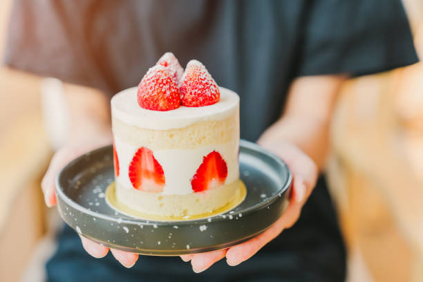 istock A woman's hand is holding a strawberry shortcake. 2149088890