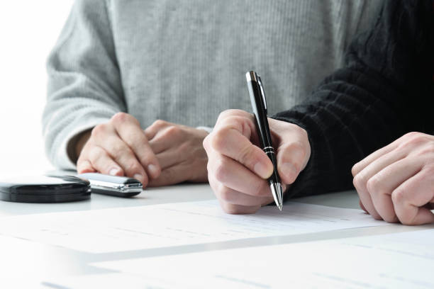 istock Couple filling out contract sheet with pen 2149089011