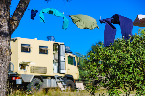 Camping on nature, rv road trip. Laundry clothes hanging to dry by camper, lorry motor home.