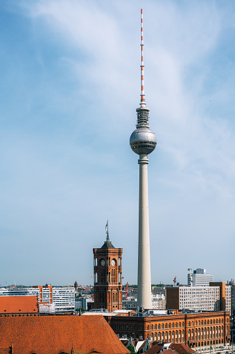 A scenic view of Berlin's skyline focusing on the Television Tower (Fernsehturm) amidst historical buildings under a blue sky.