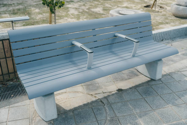 A single blue bench sits in a park, waiting for someone to come and sit down.