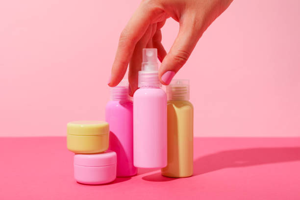 istock Cosmetic bottles and female hands on pink background 2149090959