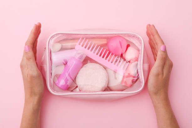 istock Bag for cosmetics and female hands on pink background, top view 2149091102