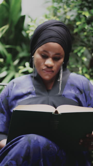 African woman wearing hijab reading a book