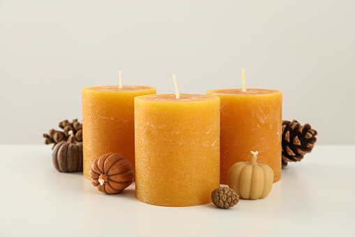 Orange candles and cones on white background