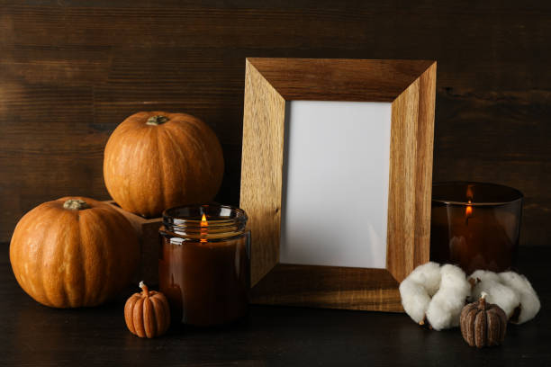 istock Candles, pumpkins and photo frame on wooden background 2149091806