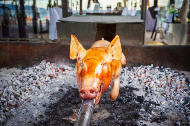 Lamb on a spit Greek style, Whole lamb on a rotisserie spit, Open fire Spit Roasting Lamb for Greek Easter