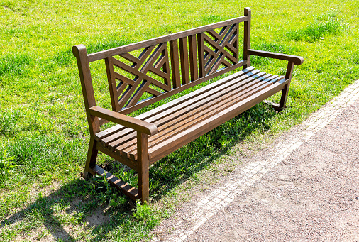 Wooden bench for rest at the city park in summer sunny day