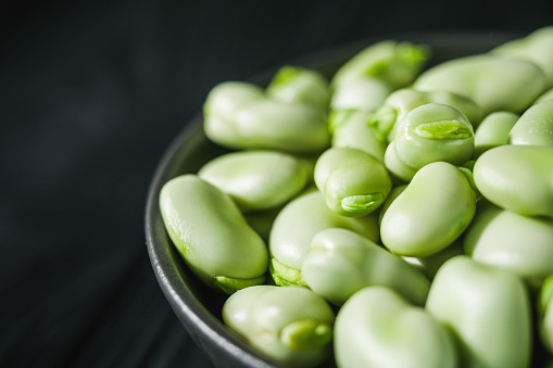 fresh greens broad beans fava on a dark background.