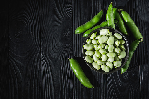 fresh greens broad beans fava on a dark background.