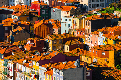 Old architecture with red tile rooftops in Porto, Portugal. Famous travel destination. Colorful buildings abstract background.
